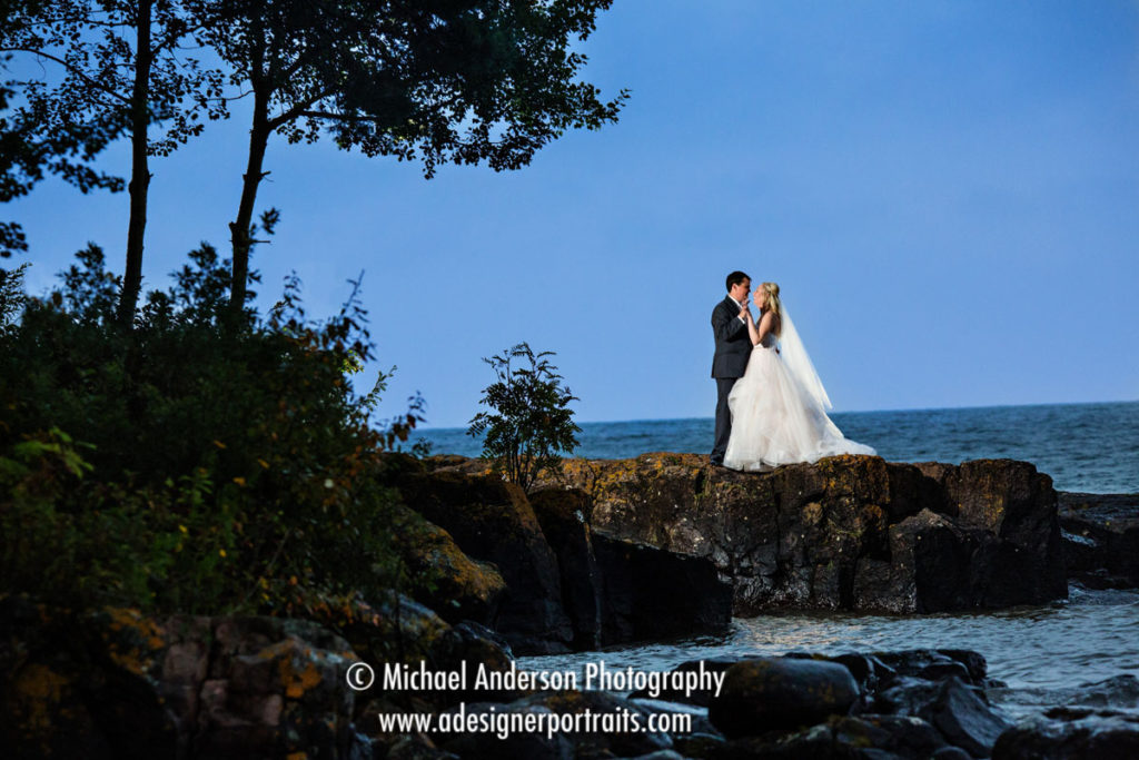 A pretty destination wedding photograph taken on a rocky ledge at Grand Superior Lodge on Lake Superior.