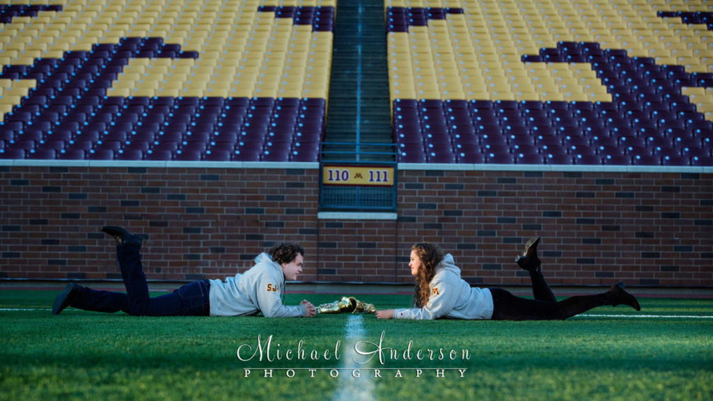 Engagement Portraits at TCF Bank Stadium. Cute engagement portrait of Sam and Taylor on the 50 yard line at TCF Bank Stadium. This is where they met when they were students and in the University of Minnesoat Marching Band together.