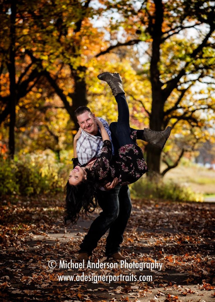 A cute couple having some fun in the leaves during their Long Lake Regional Park engagement portraits.