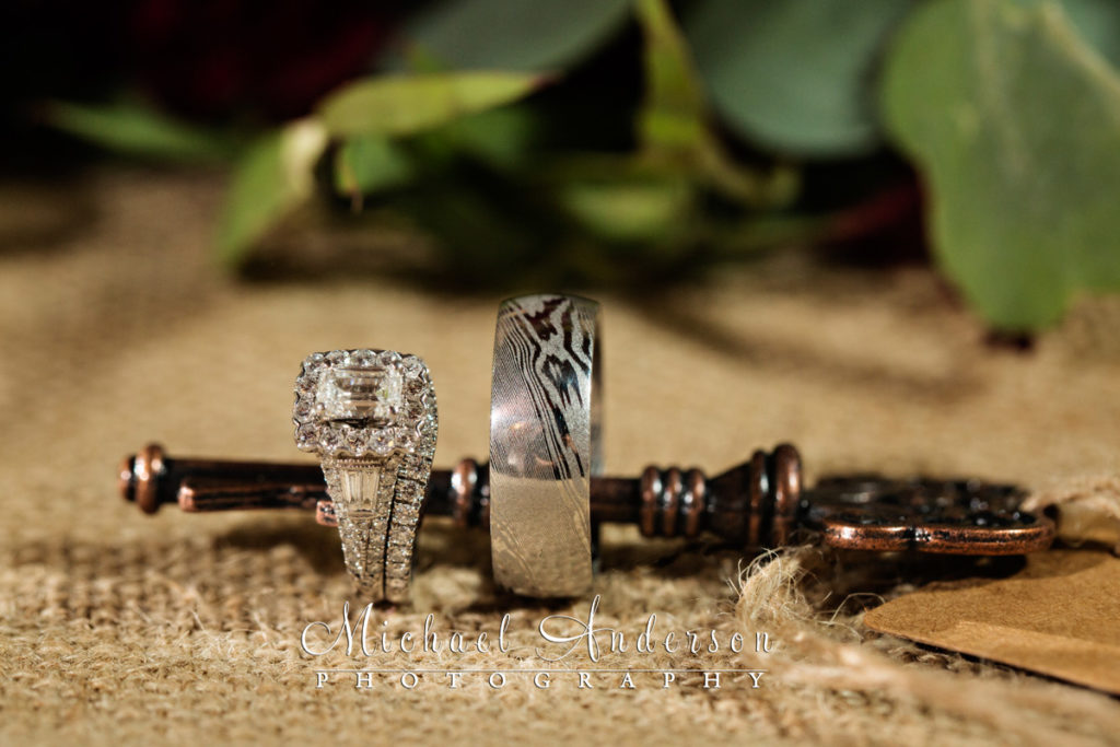 Wedding details photograph of Eric and Amanda's wedding rings on a key. Image taken at their Minnesota Horse and Hunt Club wedding reception on October 21, 2017.