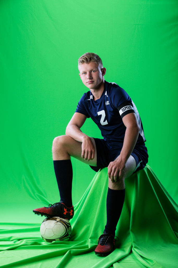 Senior portrait of a soccer player on green screen before playing him in a composite.