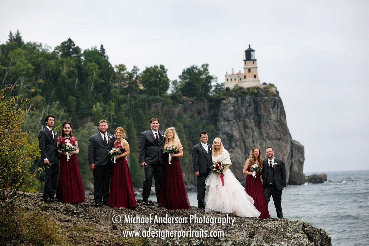 A pretty, classic wedding portrait of a bride and groom with their wedding party at the famous Split Rock Lighthouse.