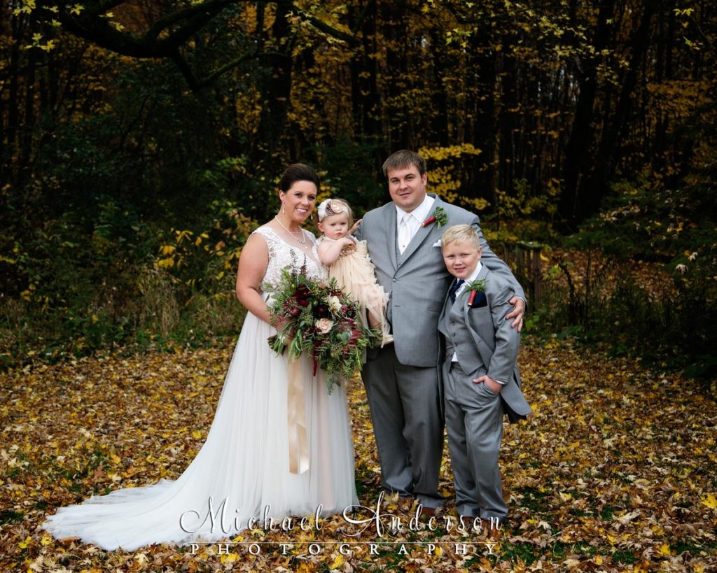 Family portrait of the bride, groom and their two cute kids taken on their wedding day just before their Minnesota Horse and Hunt Club wedding ceremony.