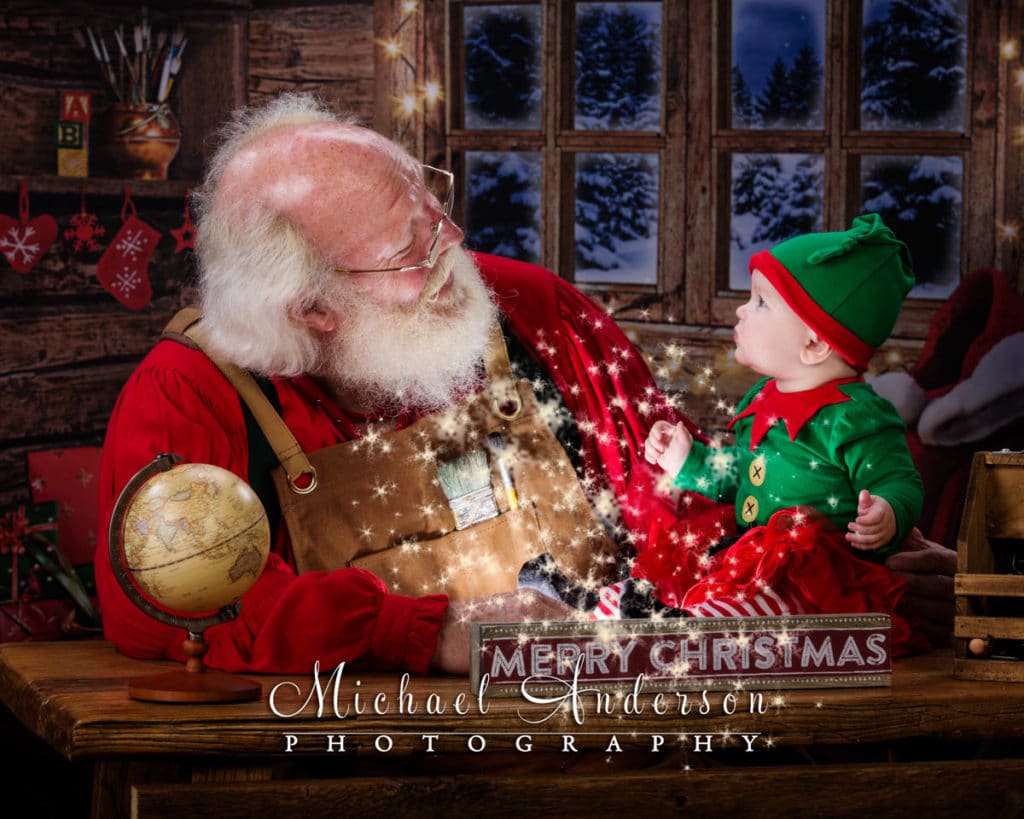 An adorable six month old baby girl sees Santa's Magic for the first time. Photograph was created at The Santa Experience at Santa's Workshop.