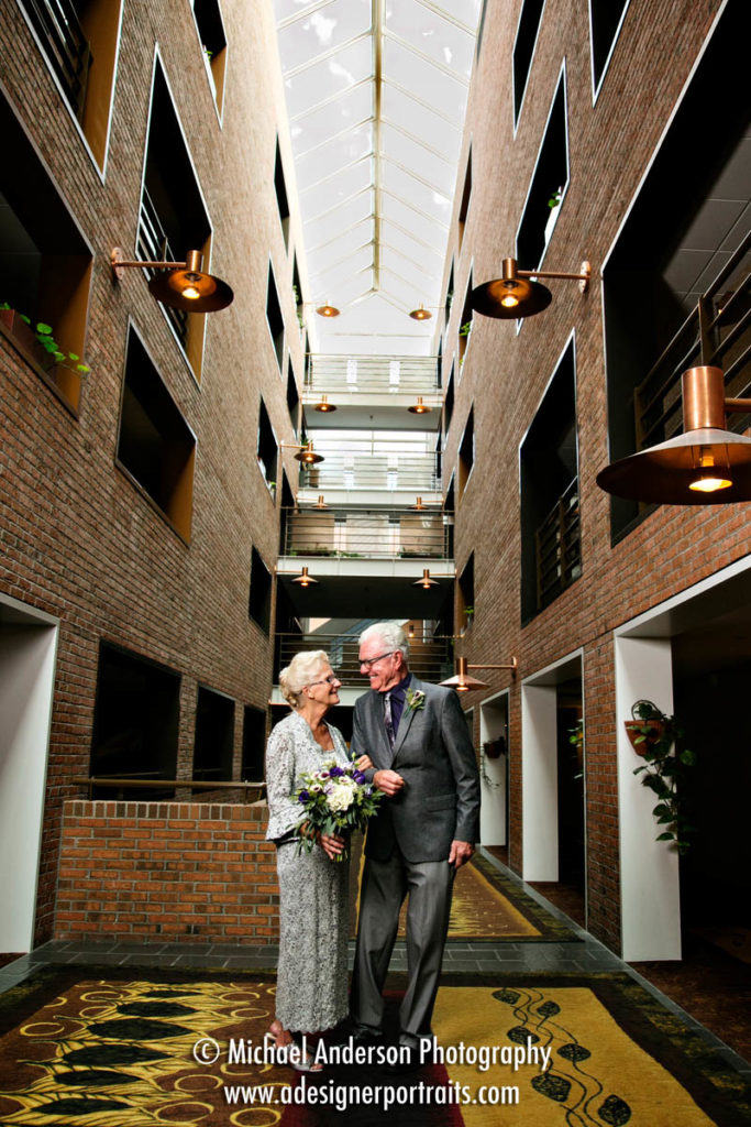 A wide angle wedding photo of the bride and groom created in the atrium at the hotel. Photograph was taken before their Crowne Plaza Plymouth wedding.