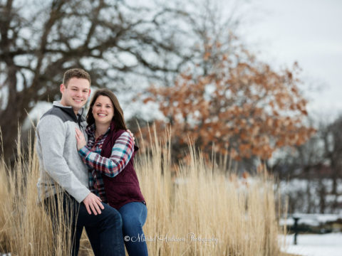 Minnehaha Falls winter engagement portraits of a cute couple in the snow and long grasses.