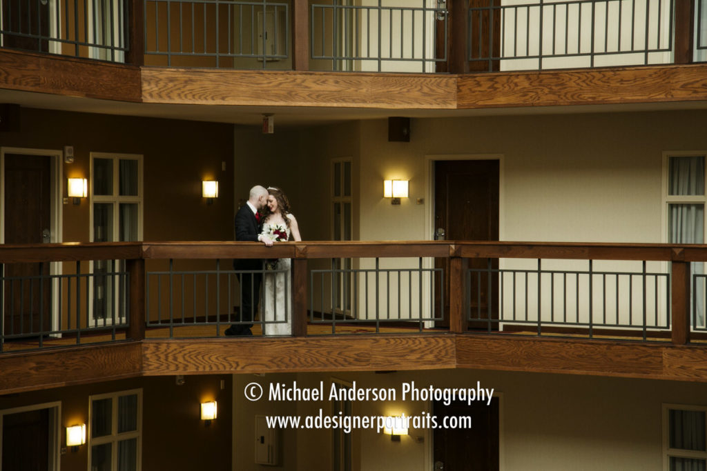 Wedding photography Minneapolis Marriott Northwest. Bride and groom kissing on the balcony at the hotel.