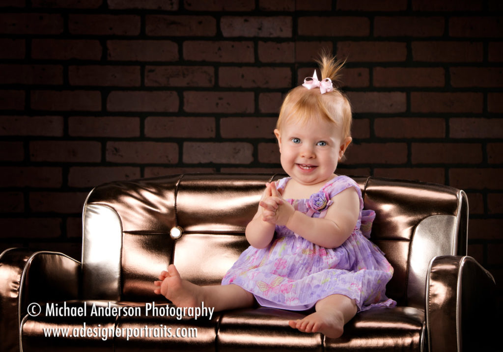 Katie's First Birthday Portraits in her cute dress on our metallic couch.