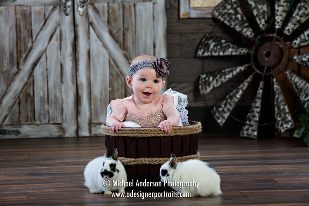 Mounds View MN Portrait Photographer Easter Bunny Photographs. A really cute Easter photo of a cute baby girl in a wooden bucket with two real bunnies nearby.