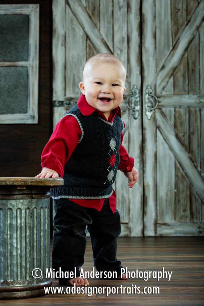 Marcus' one-year-old photos barefoot and wearing a cute sweater vest.