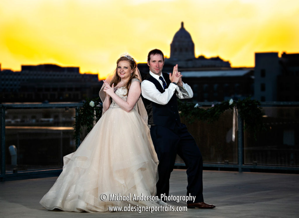 Pretty rooftop sunset A'BULAE Wedding Photographs. A fun photo of the bride and groom doing a "Charlie's Angels" pose. The Minnesota State Capitol building is in the background.
