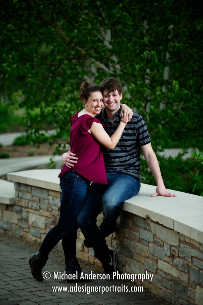 Silverwood Park engagement portraits in Saint Anthony, MN. A cute couple by a stone wall at the pretty park.
