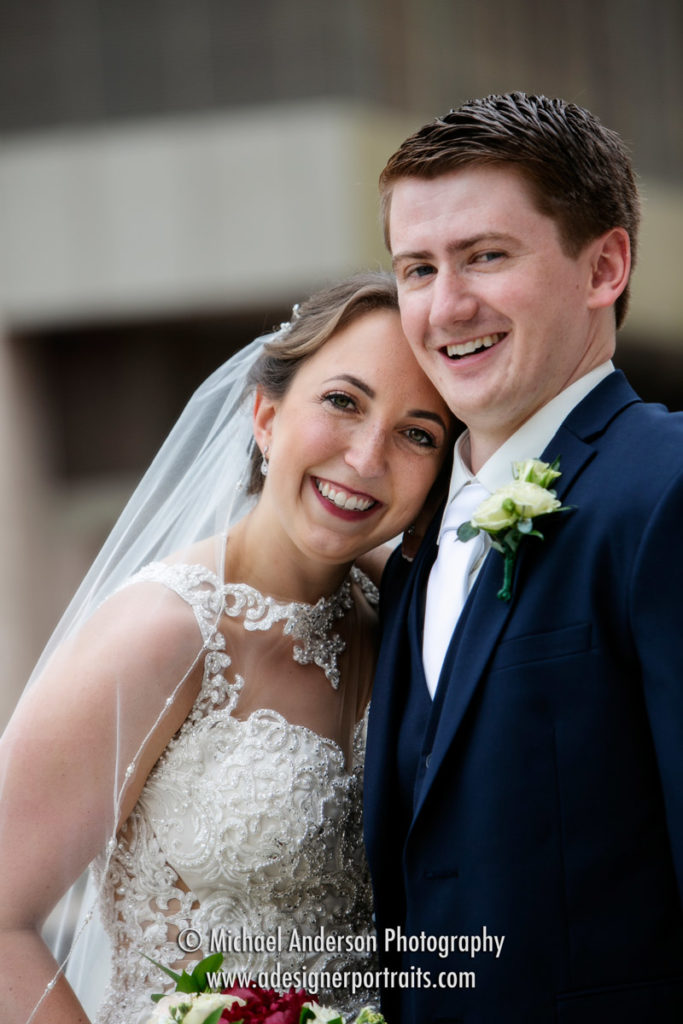 A cute candid wedding photo of the bride and groom taken near the James J. Hill Library in St. Paul, MN.