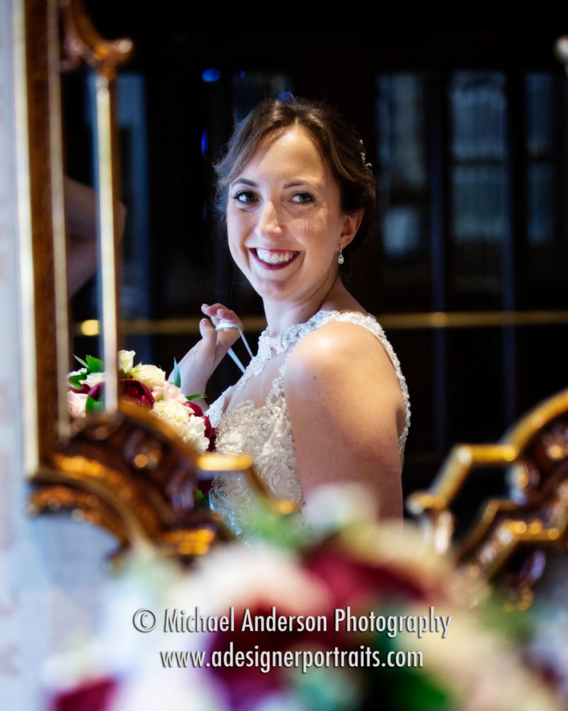 A pretty bride peaks in a mirror in The Saint Paul Hotel lobby.