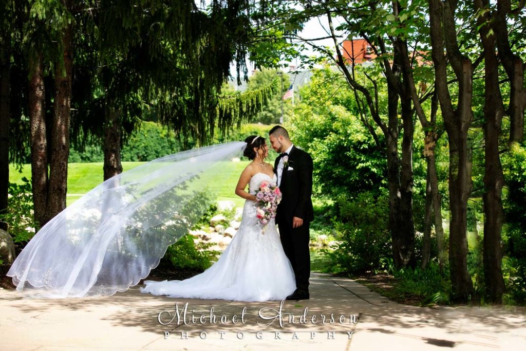 A very pretty wedding photo of a groom and bride with a flowing veil at Centennial Lakes in Edina, MN.