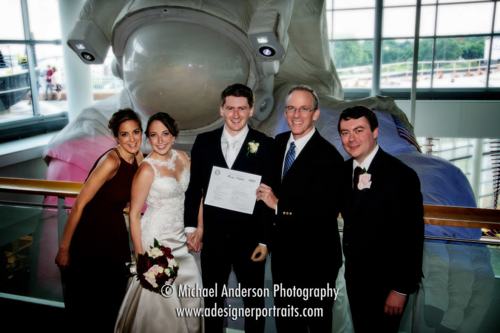 Science Museum of Minnesota wedding photo of the bride, groom, minister, Best Man, and Maid of Honor near the huge astronaut on display.