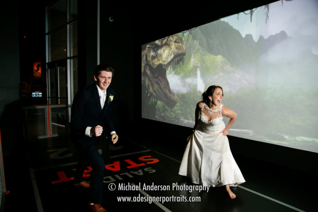 Science Museum of Minnesota wedding photo of the bride and groom racing a dinosaur!