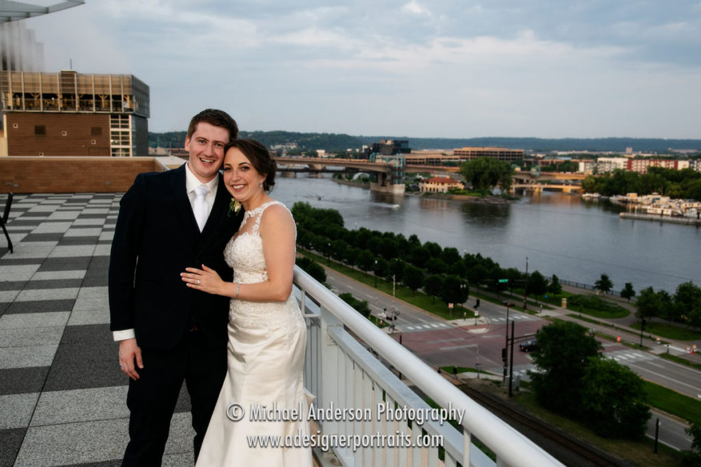 A pretty Science Museum of Minnesota wedding photo of the bride and groom on the rooftop with the Mississippi River in the background.