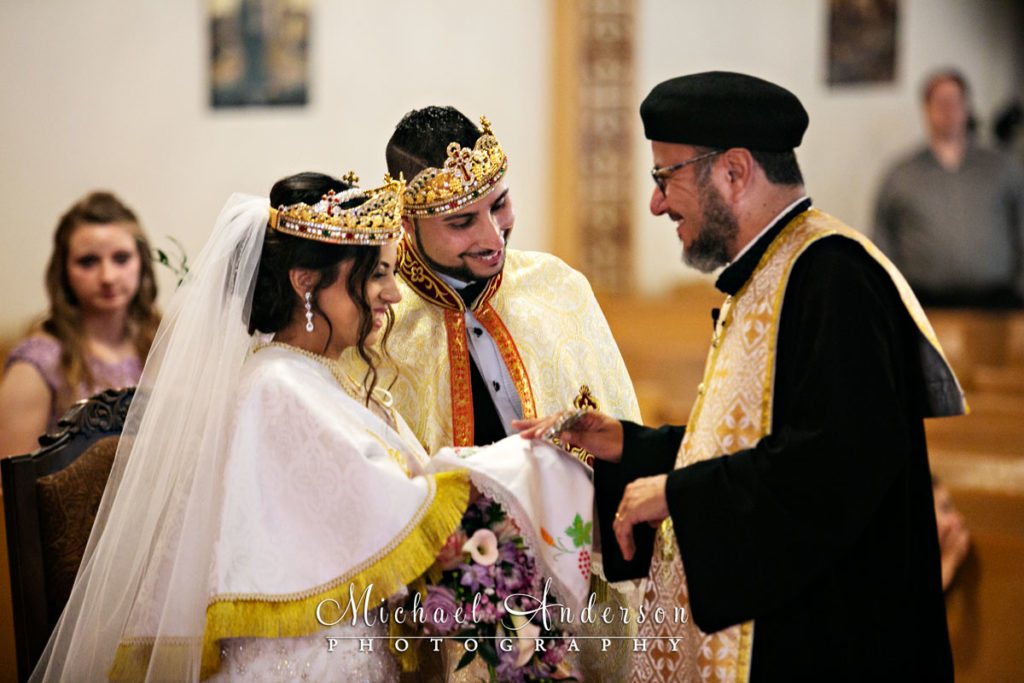 St. Mary's Coptic Orthodox Church wedding photos of the priest along with the bride and groom during a special moment in their wedding ceremony.