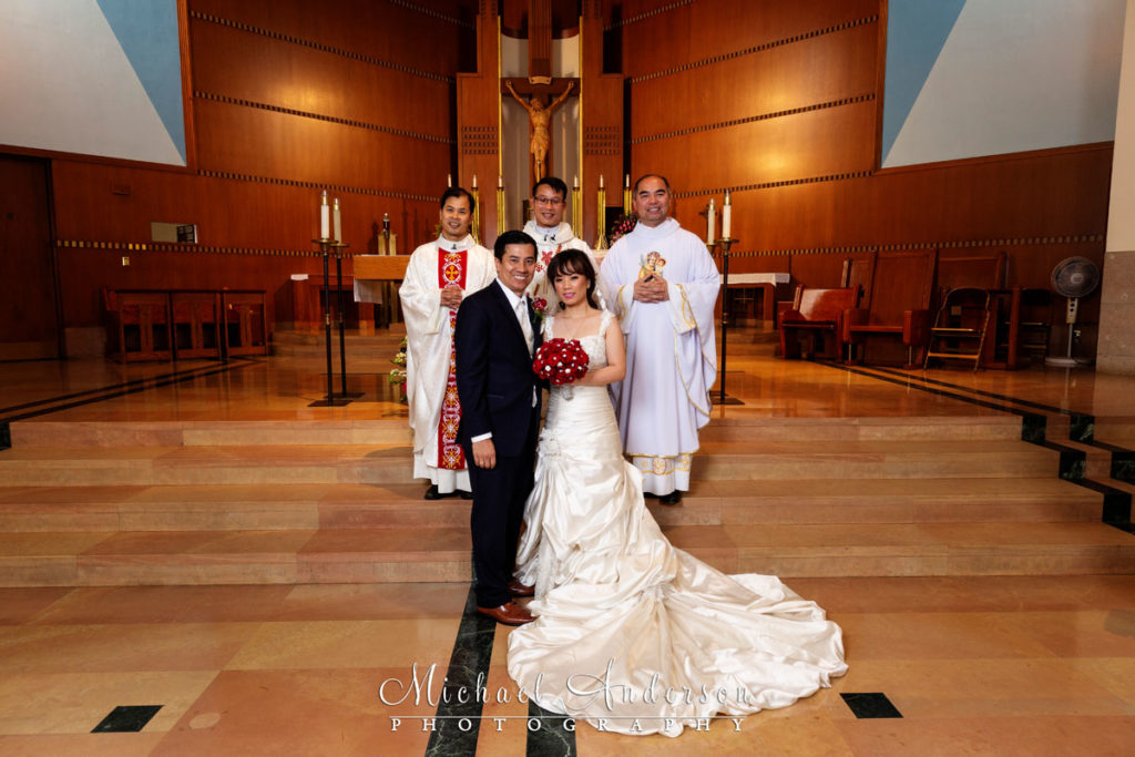Church of Saint Columba wedding photo of the bride, groom, and their priests at the altar.