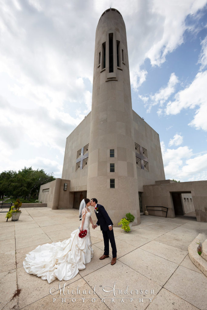 An interesting Church of Saint Columba wedding photo. Image of the bride and groom taken with an ultra-wide angle lens outside the church.