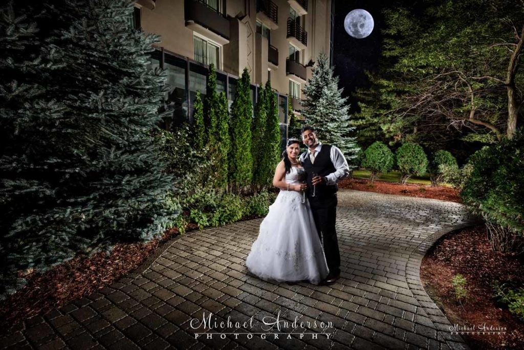 A pretty Embassy Suites Minneapolis Airport light painted wedding photo with the bride and groom under a full moon.