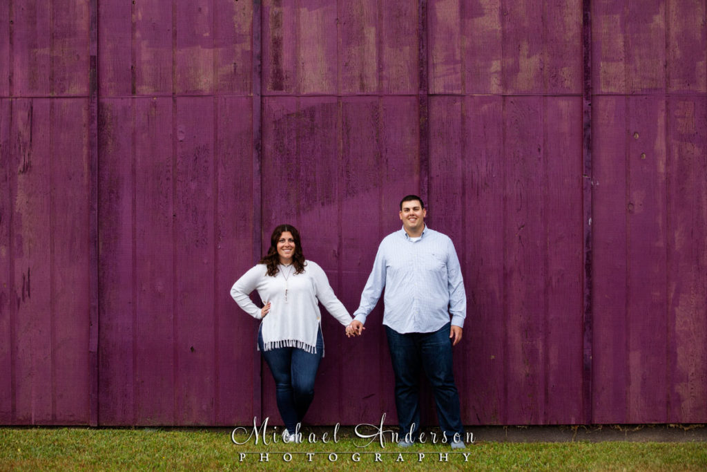 North Shore engagement photos by a purple wall in Two Harbors, MN.