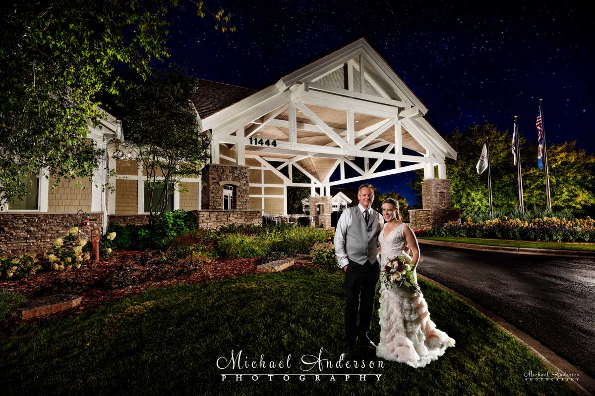 A very pretty TPC Twin Cities light painted wedding photograph of the bride and groom in front of the clubhouse.
