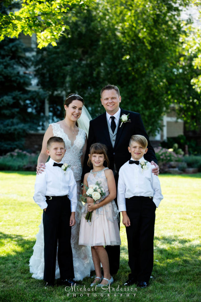 TPC Twin Cities wedding photographs of the bride and groom along with their two ring bearers and flower girl.