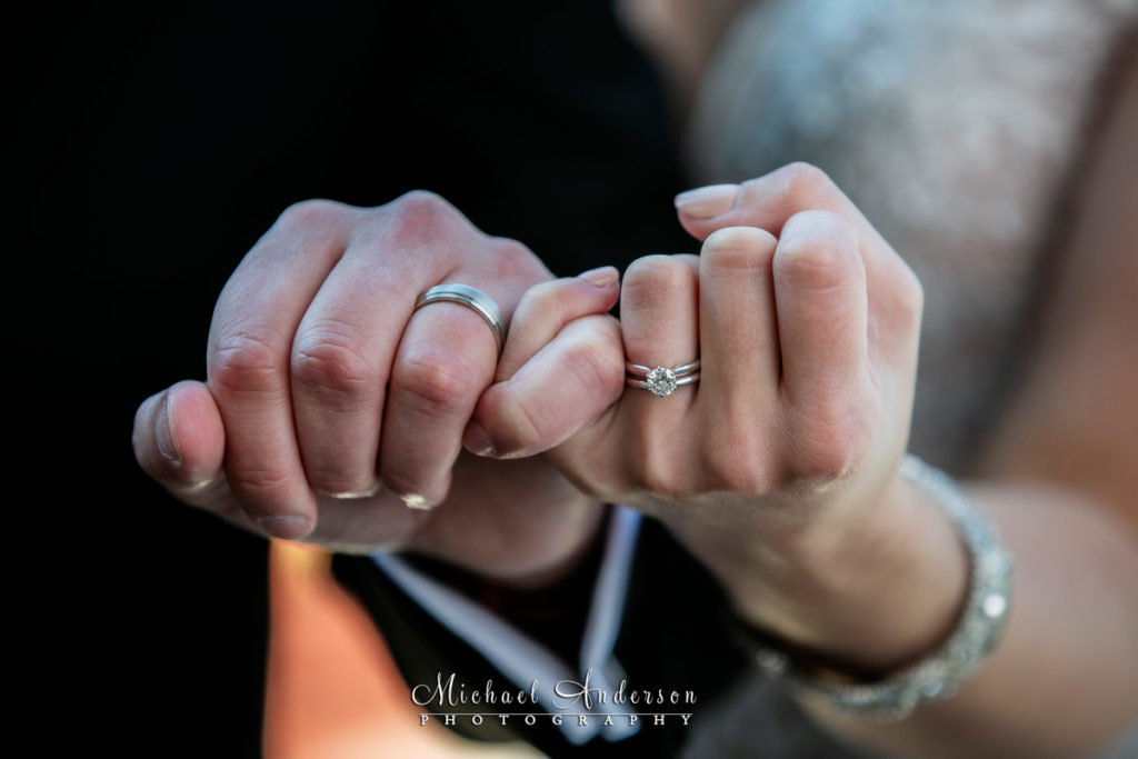 TPC Twin Cities wedding reception photos of the bride and groom's wedding rings on their hands.