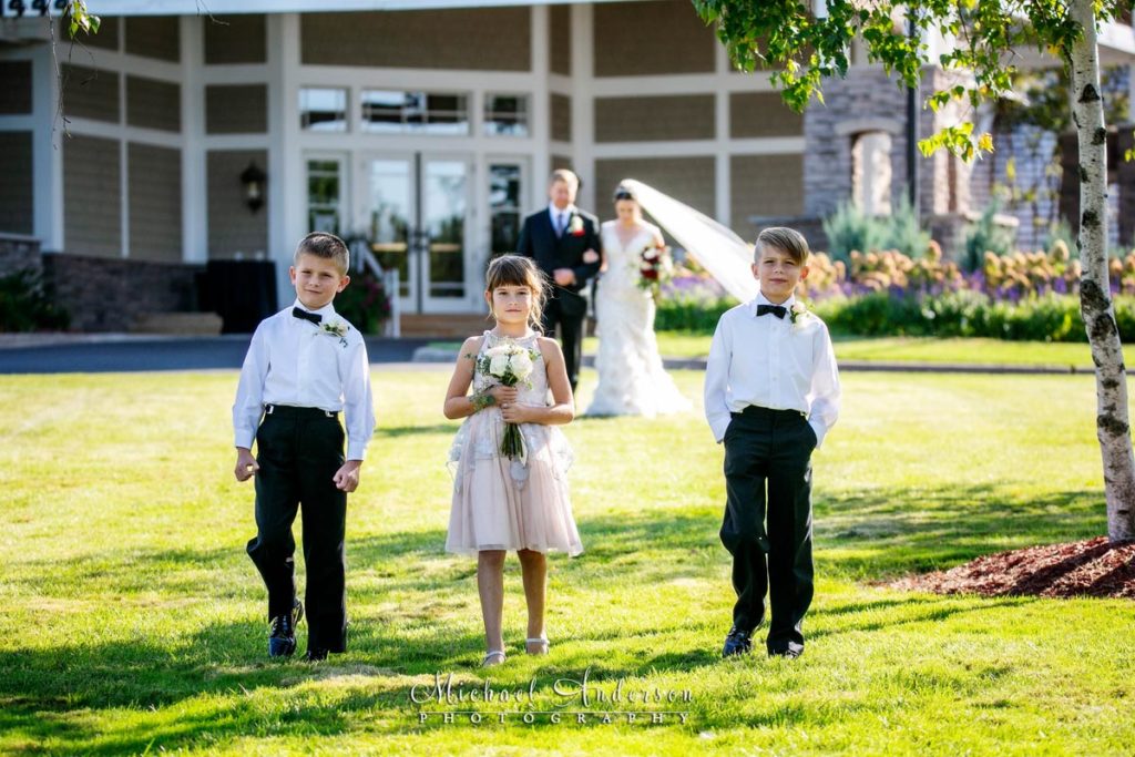 TPC Twin Cities wedding photographs of the ring bearers and flower girl with the bride and her dad in the background.