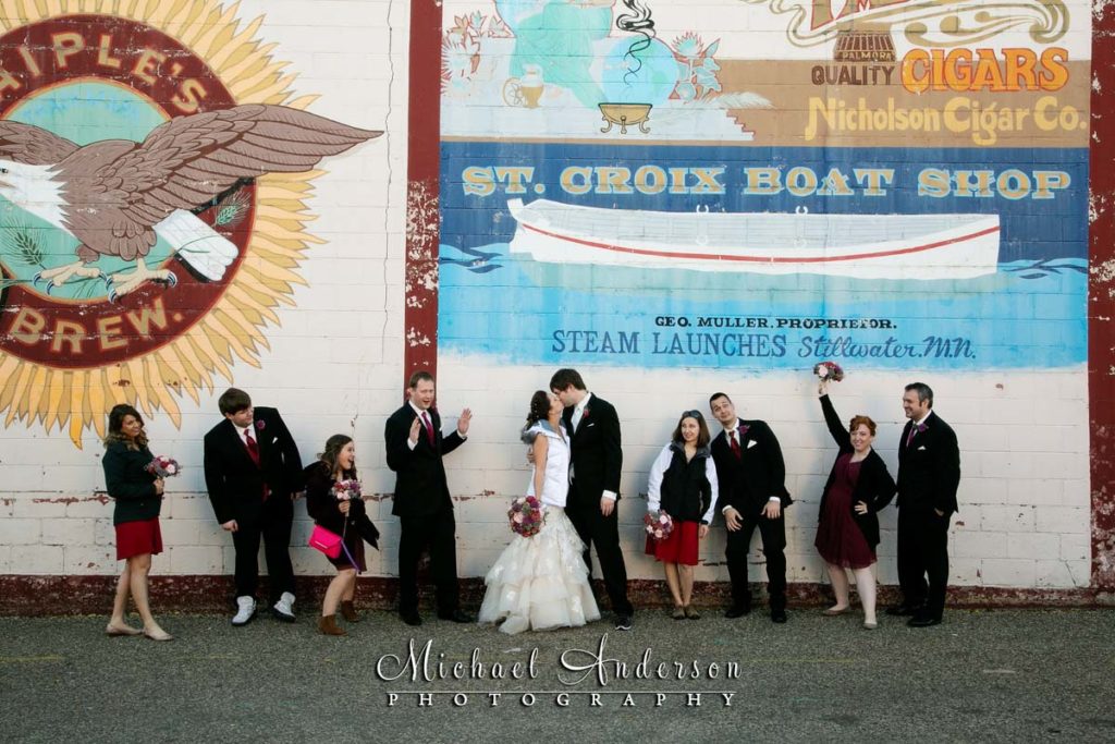 A fun wedding party photo taken in front of a mural in Stillwater, MN.