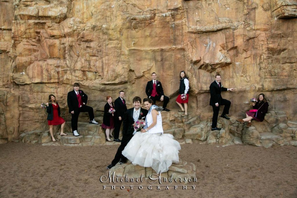 A bride, groom, and their wedding party on the rocky wall at Teddy Bear Park in Stillwater, MN.