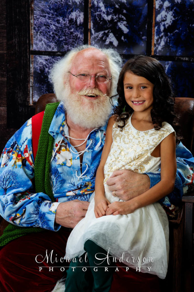 Four sisters meet Santa Claus and one of them, Evalyn, sits with Santa in this portrait.