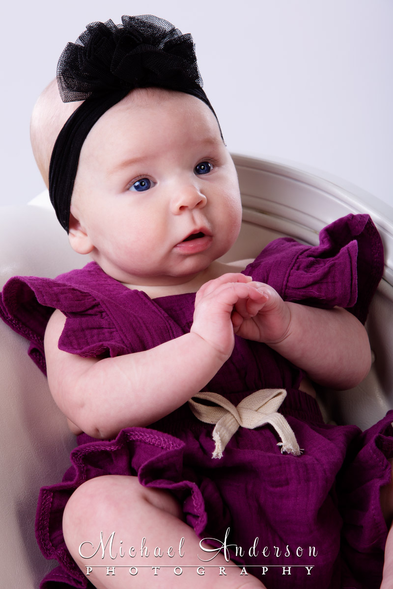 A studio portrait of a cute little three-month-old baby girl.