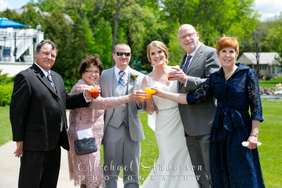 The bride, groom, and both sets of parents toasting the newlyweds just after their wedding on White Bear Lake.