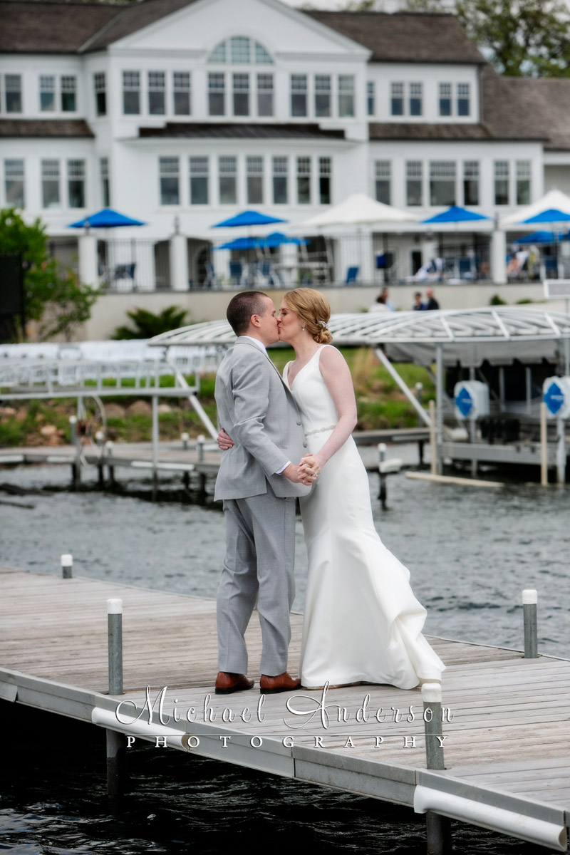 Bride and groom kissing on the boat dock just after their wedding on White Bear Lake.