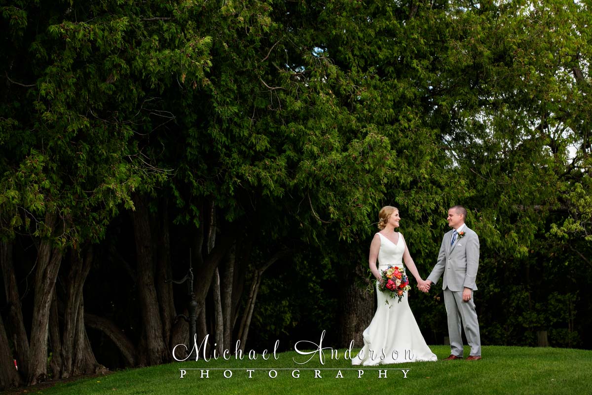A pretty photo of the bride and groom outdoors in the cedar trees after their wedding on White Bear Lake.