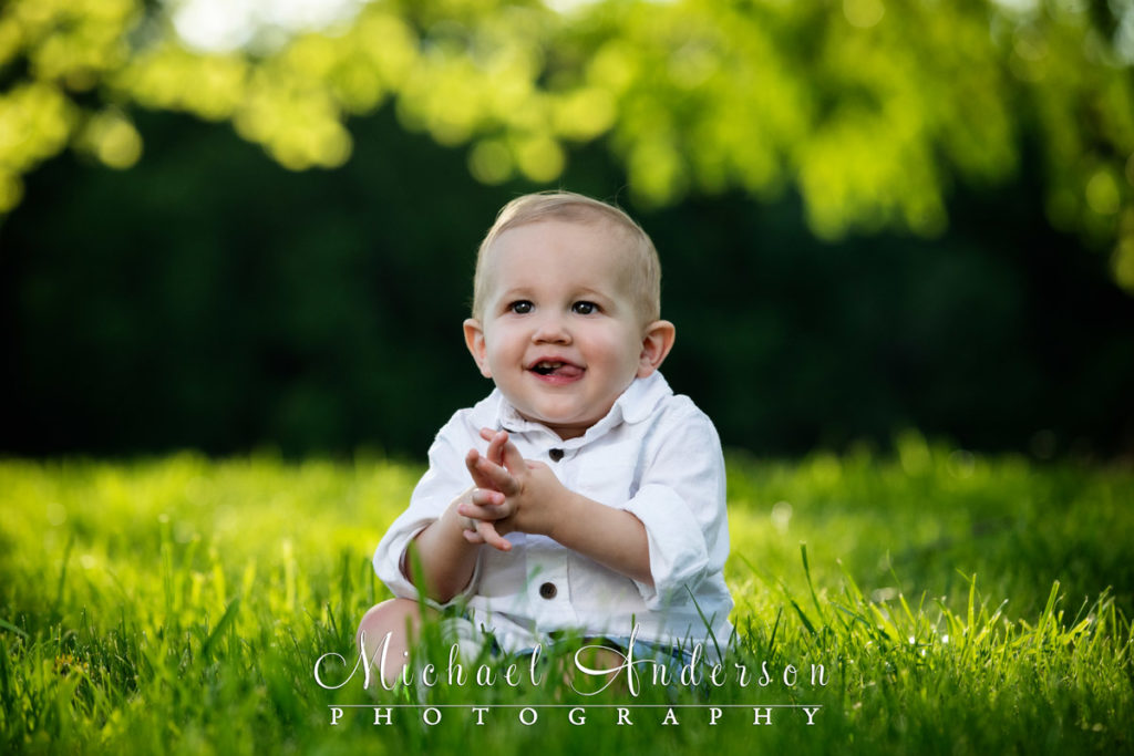Easton is one-year-old! His portrait in a grassy field.