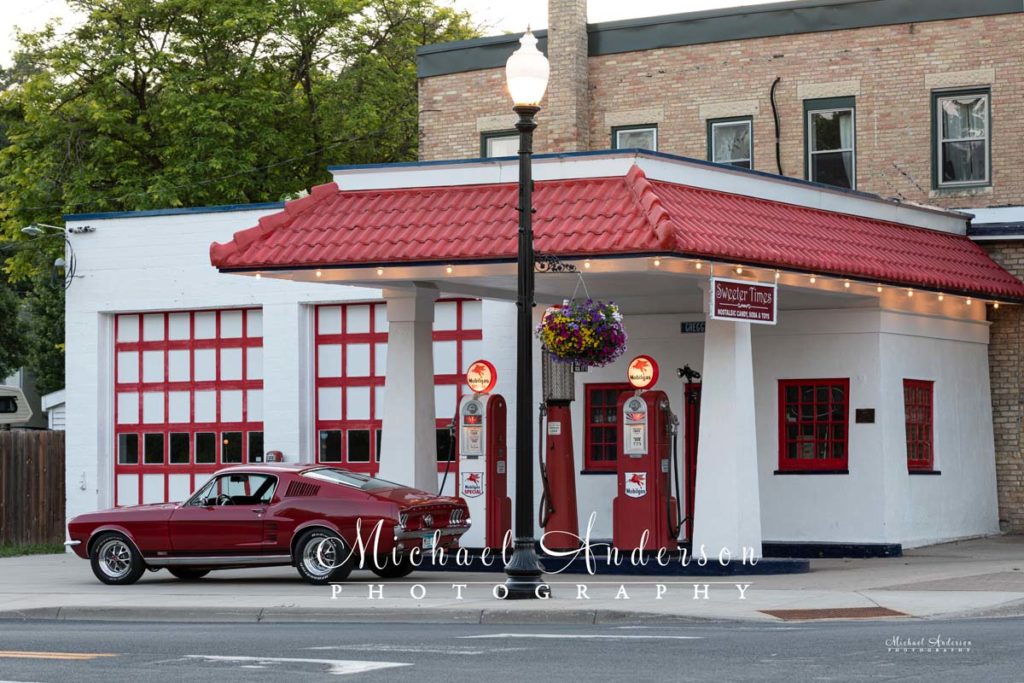 A nice photo of a 1967 Ford Mustang in front of Gregg's Garage Vintage Restored Gas Station.