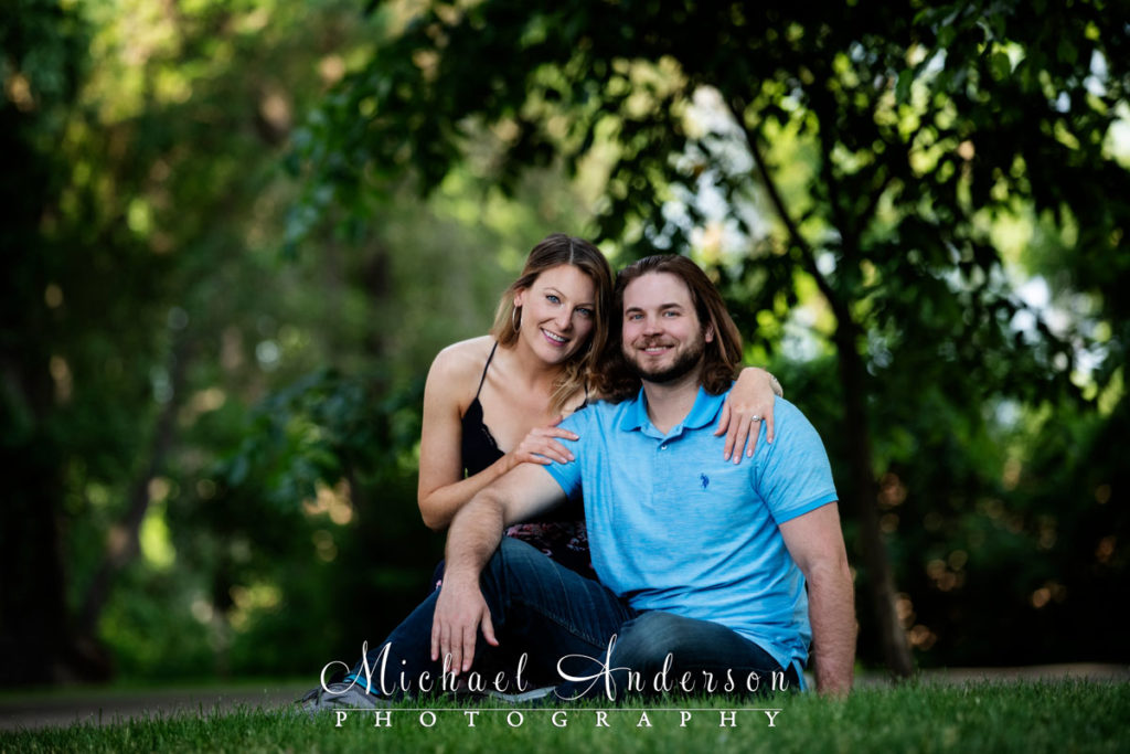 Saint Anthony Main engagement photography of a cute couple sitting in the grass.
