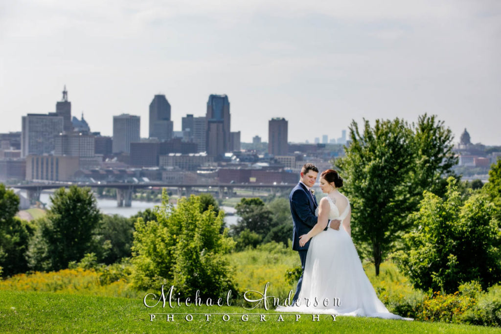 Bride and groom with the city of St. Paul, MN in the background. Photo was taken at Indian Mounds Regional Park.