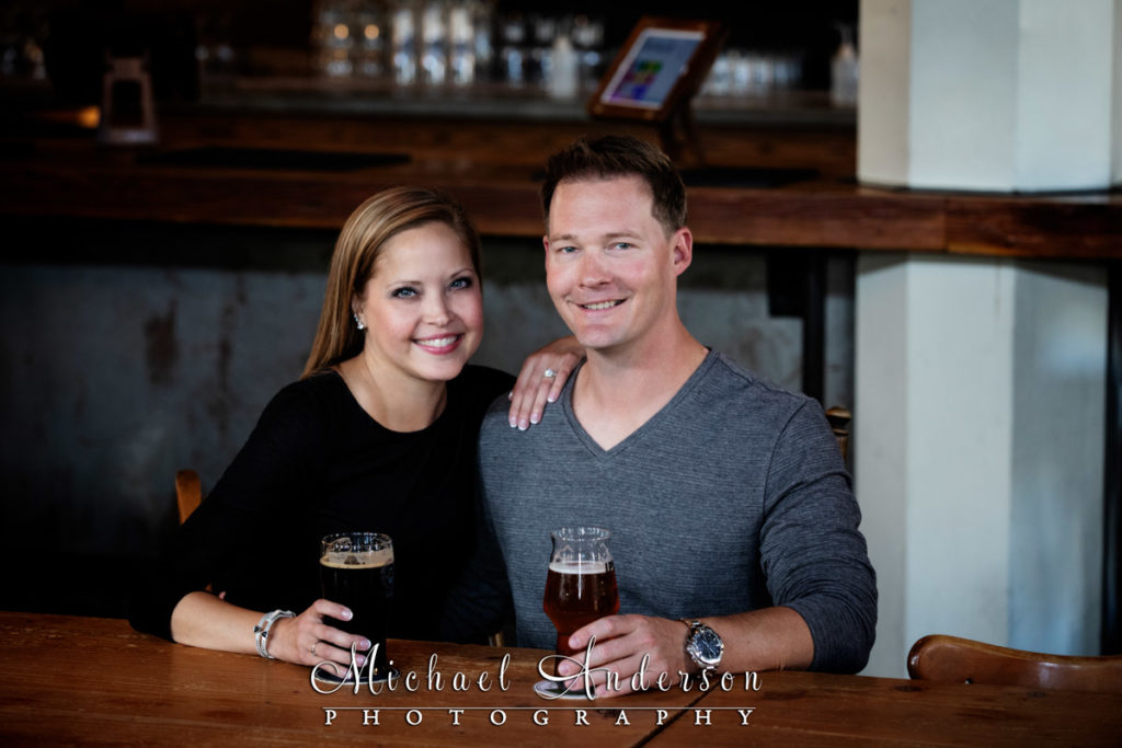 A cute engagement pic of a couple toasting at The Dangerous Man Taproom in Minneapolis, MN.