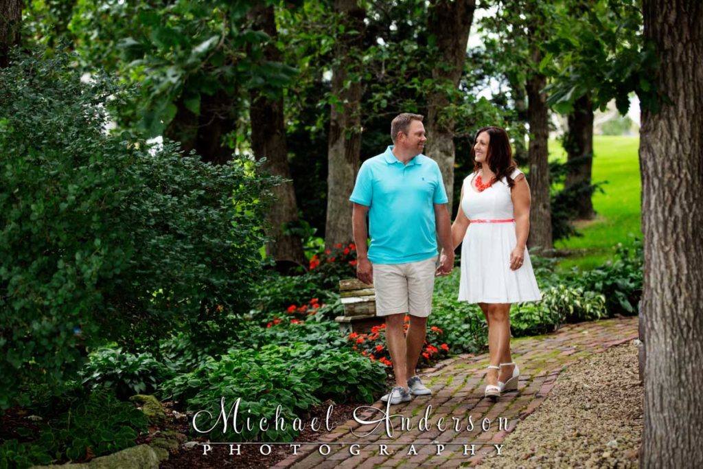 Little Log House Pioneer Village engagement photo of a couple walking down a pretty path.