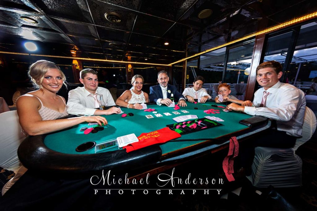 The bride and groom, along with their wedding party, at the Texas Hold'em table during their Paradise Lady wedding reception.