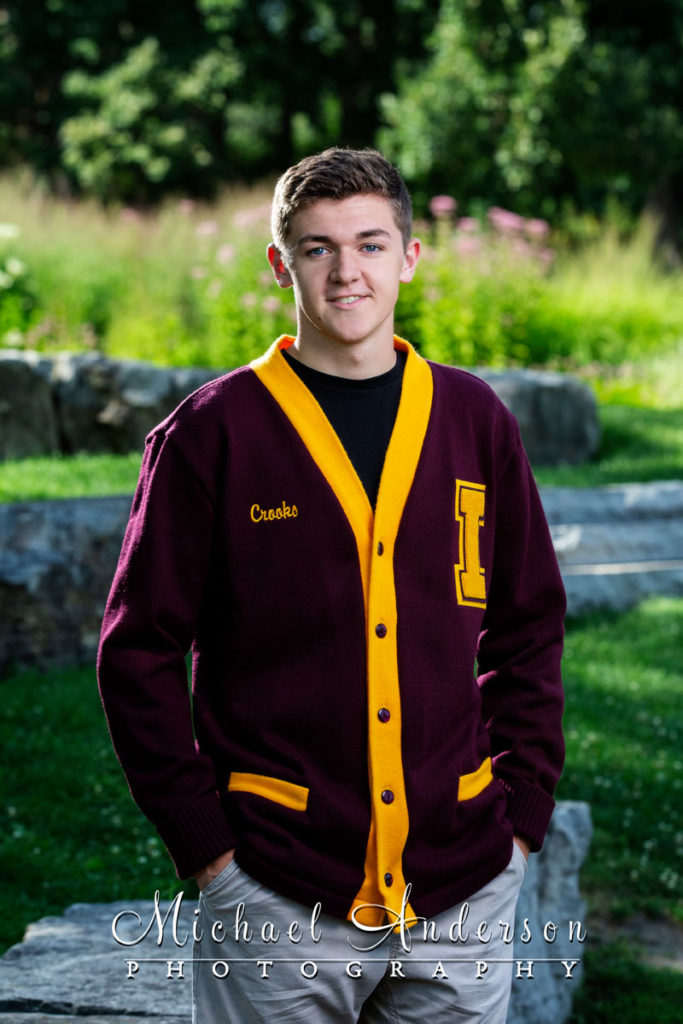 Senior portraits at Silverwood Park of a boy wearing an Irondale letterman sweater.