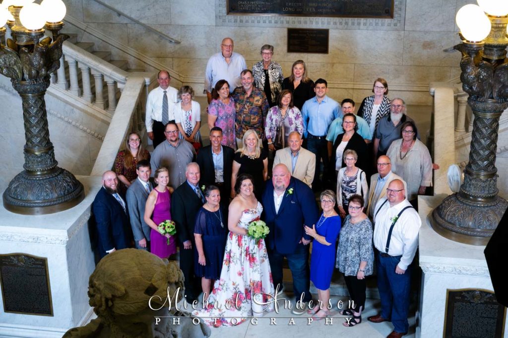 A group photo of the bride, groom, and all of their wedding guests at the Minneapolis City Hall.