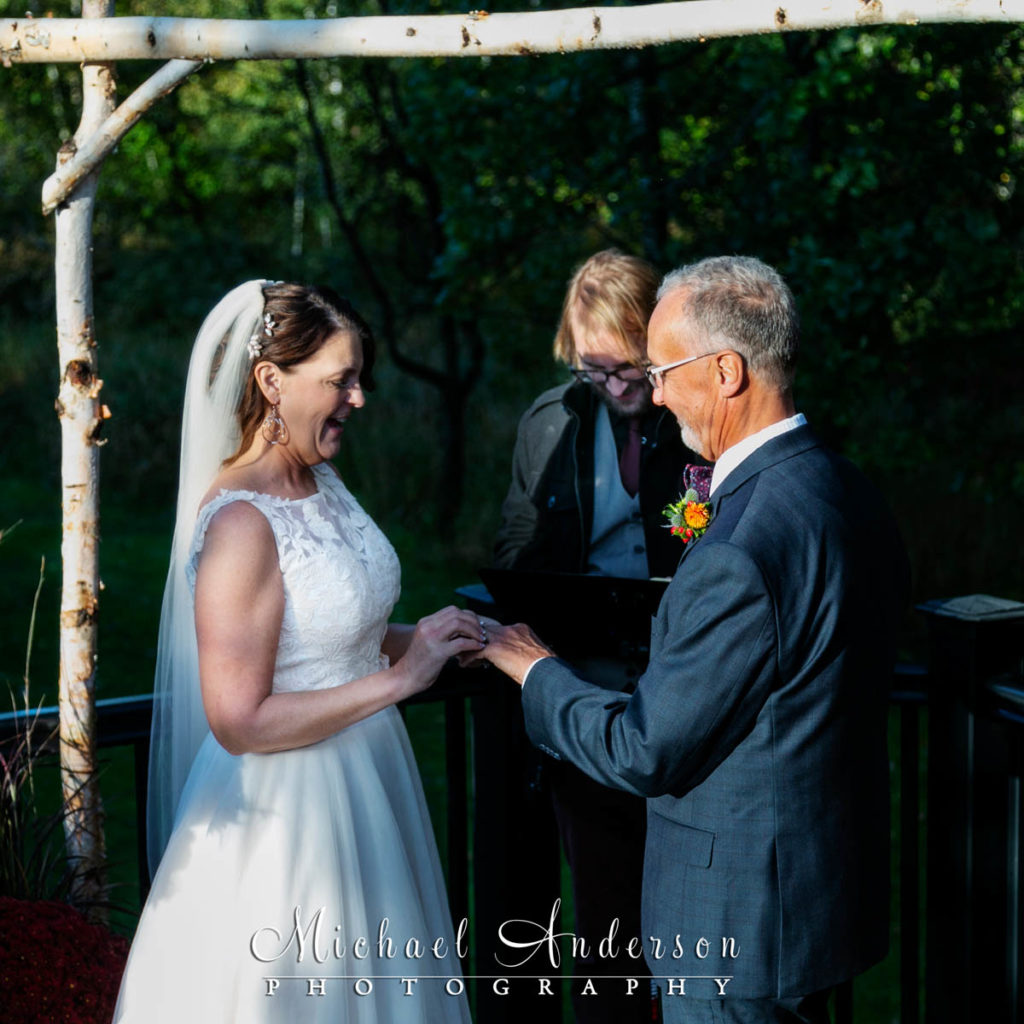 The bride and groom share their wedding vows during their beautiful backyard wedding.