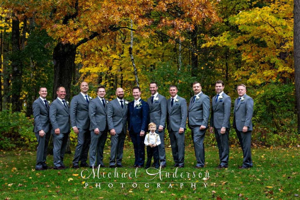 The groom and his groomsmen pose in the falling snow during his Grandview Lodge wedding day.