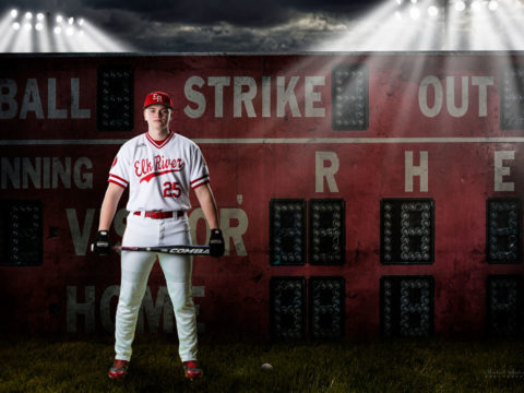 Elk River High School senior portrait green screen composite. A baseball player, with his bat, standing in front of a scoreboard.